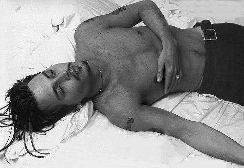Johnny Depp - Johnny Depp lying on bed shirtless.jpg